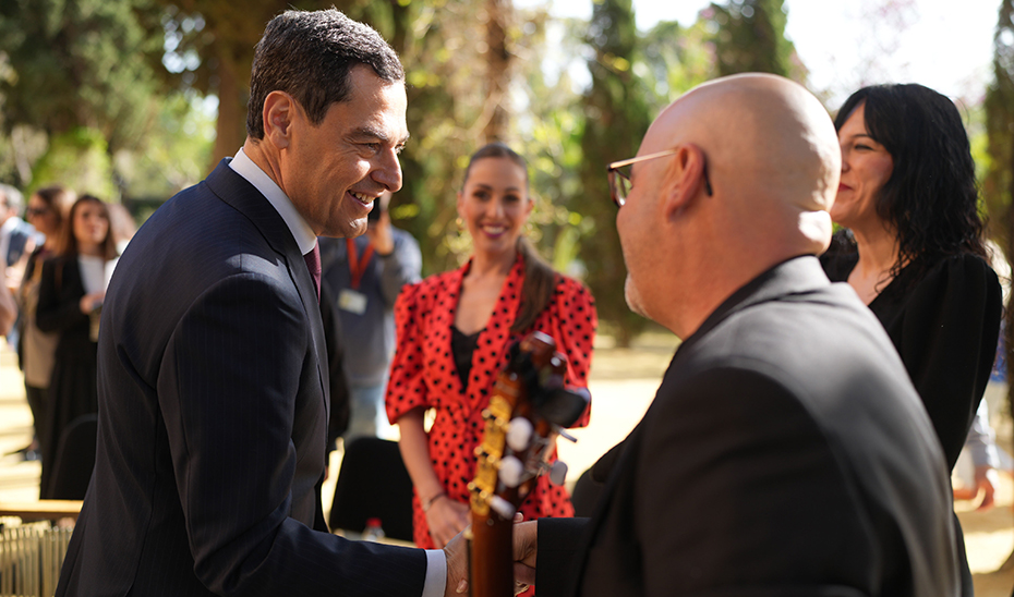 Juanma Moreno saluda a los músicos que han participado en el acto.